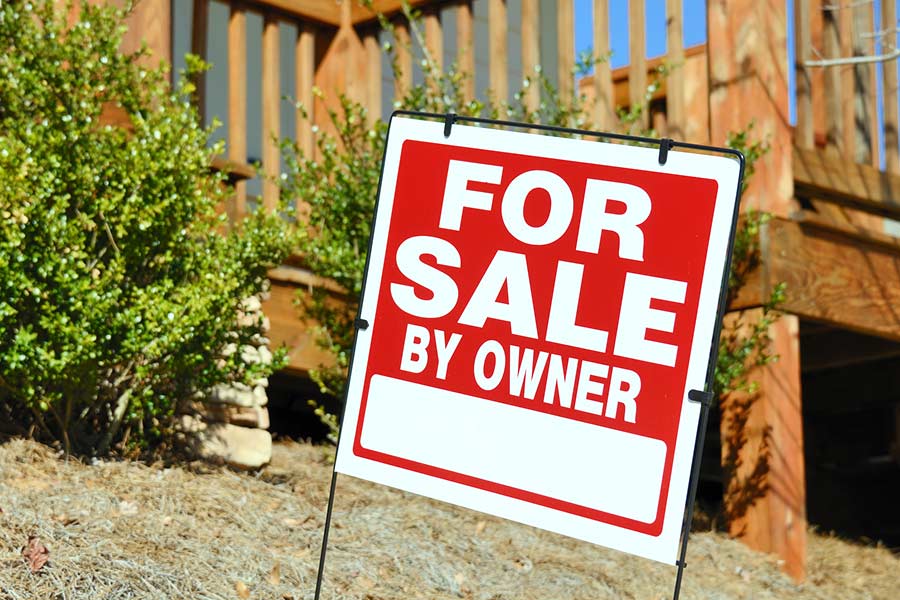 "For Sale by Owner" sign outside a home