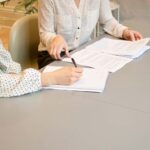 Real Estate Agent helping a prospective buyer with documentation
