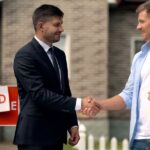 An image of a happy real estate agent and a happy couple closing a sell.