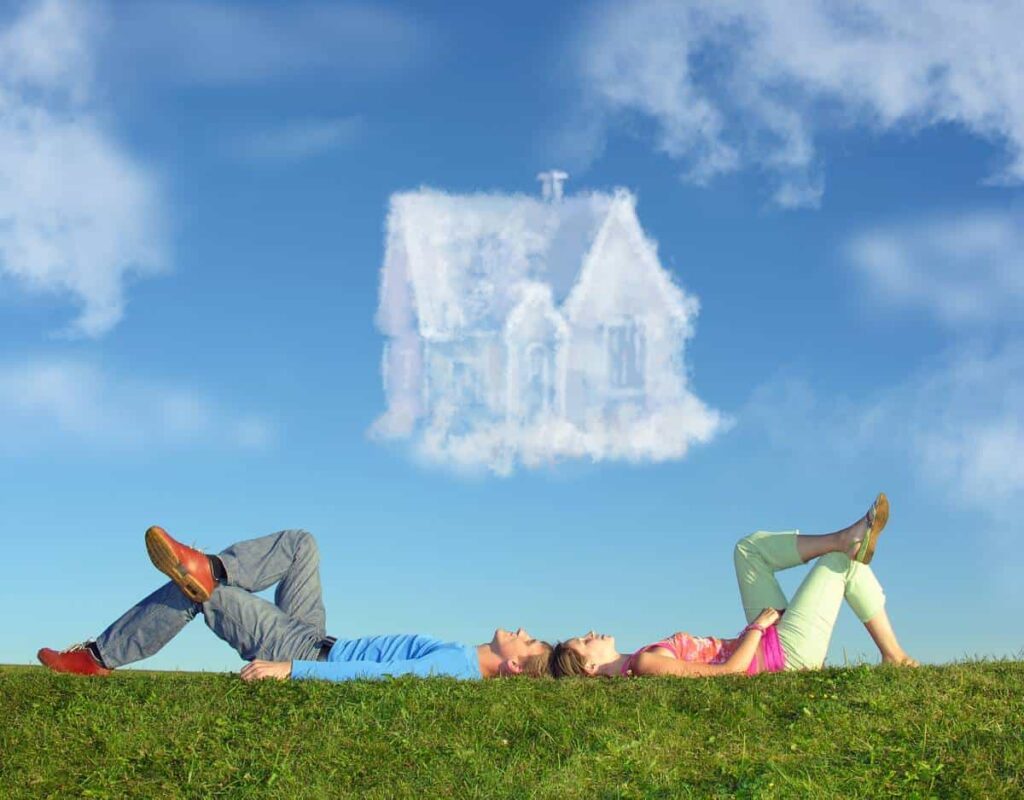 couple laying on the grass dreaming of their first home realty in Bastrop TX