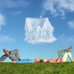 couple laying on the grass dreaming of their first house