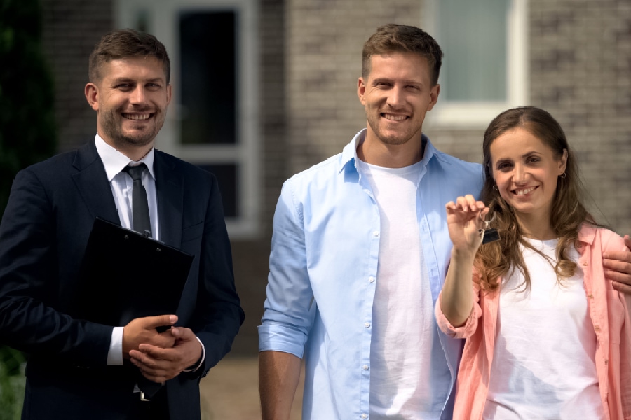 An image of a happy couple showing their new house keys thanks to an expert real estate agent