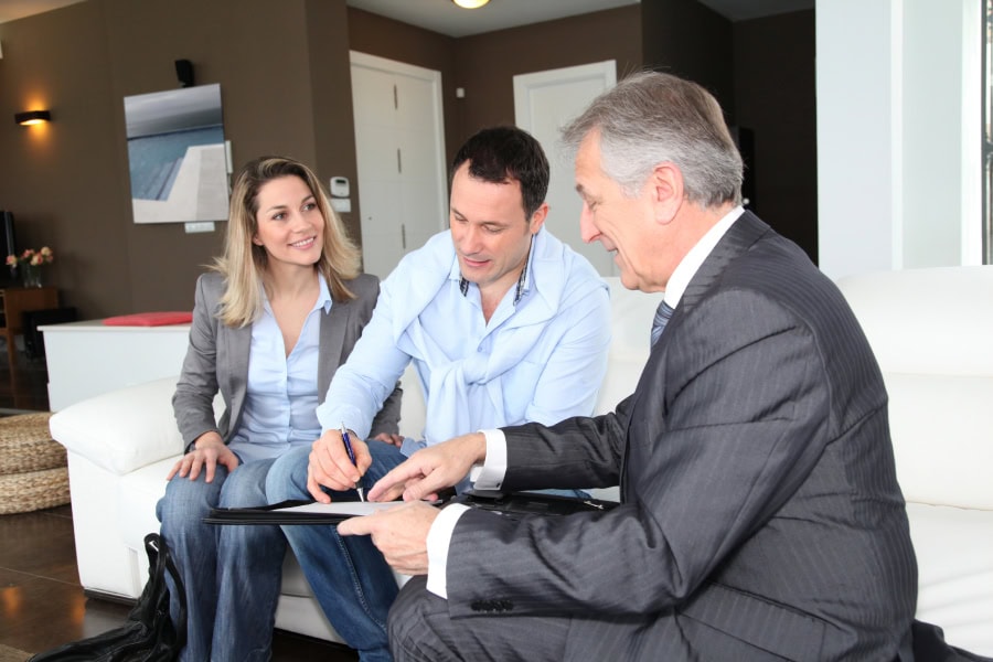 Caldwell County realtors discussing a home sale with clients in a modern living room.