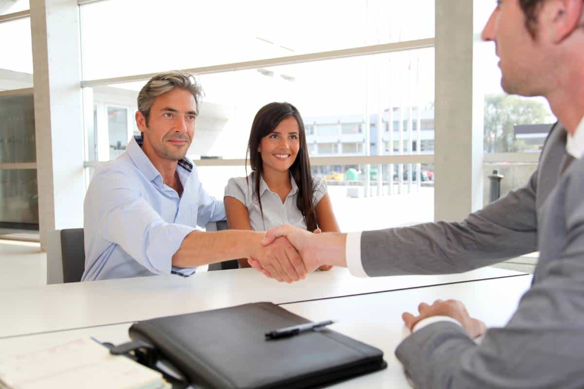 couple of real estate investors handshaking a real estate agent