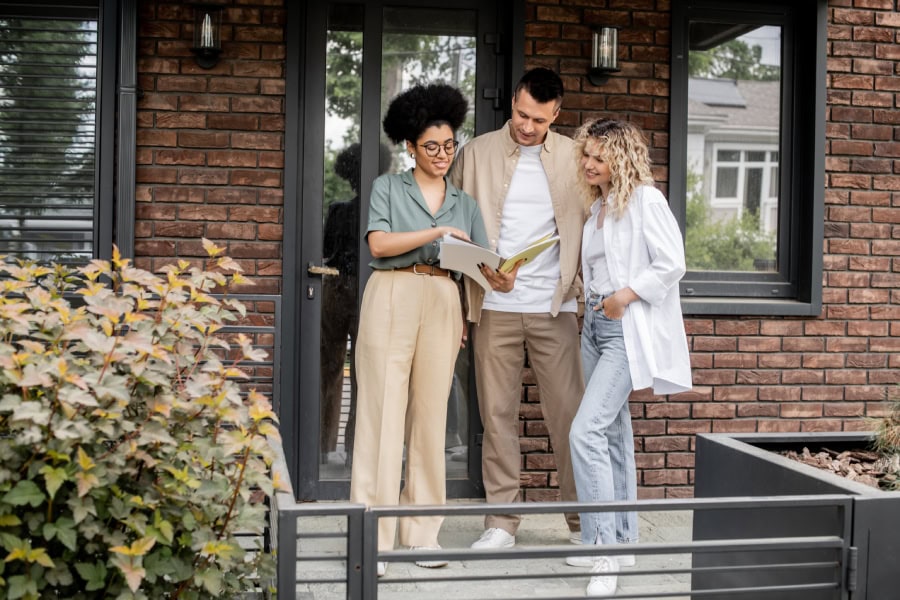 An agent reviewing real estate in Caldwell County with a young couple.