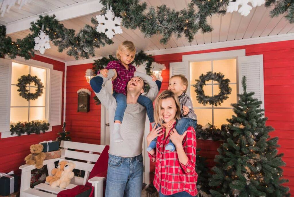 Family Enjoying Together Christmas Decorations In Their Property
